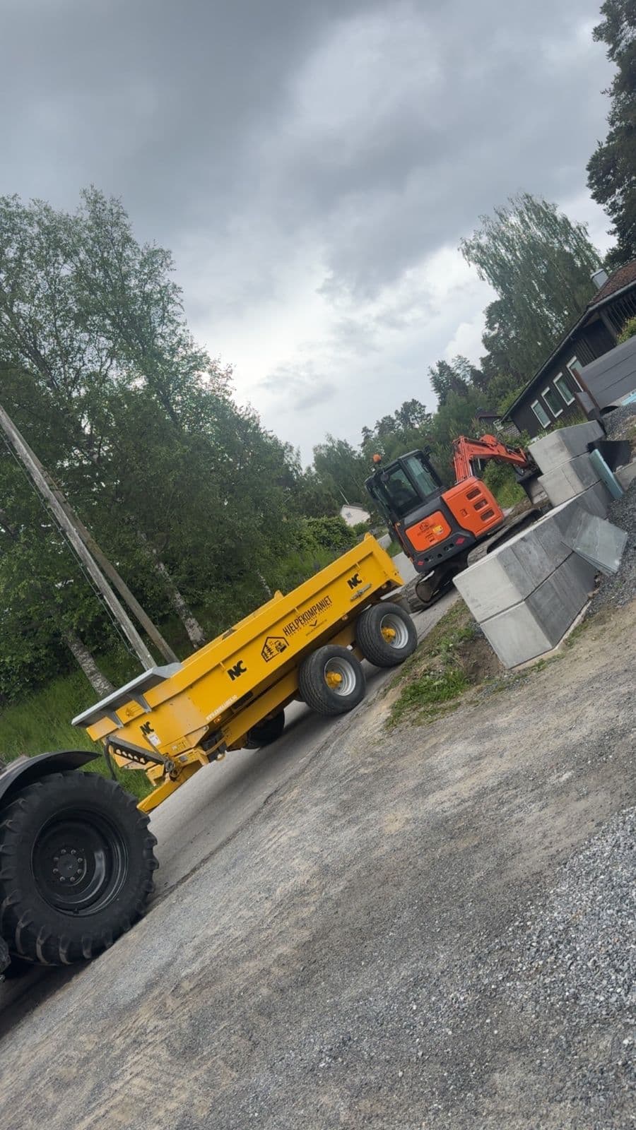 Gravemaskin og tipphenger fra Hjelpekompaniet i arbeid ved en oppkjørsel