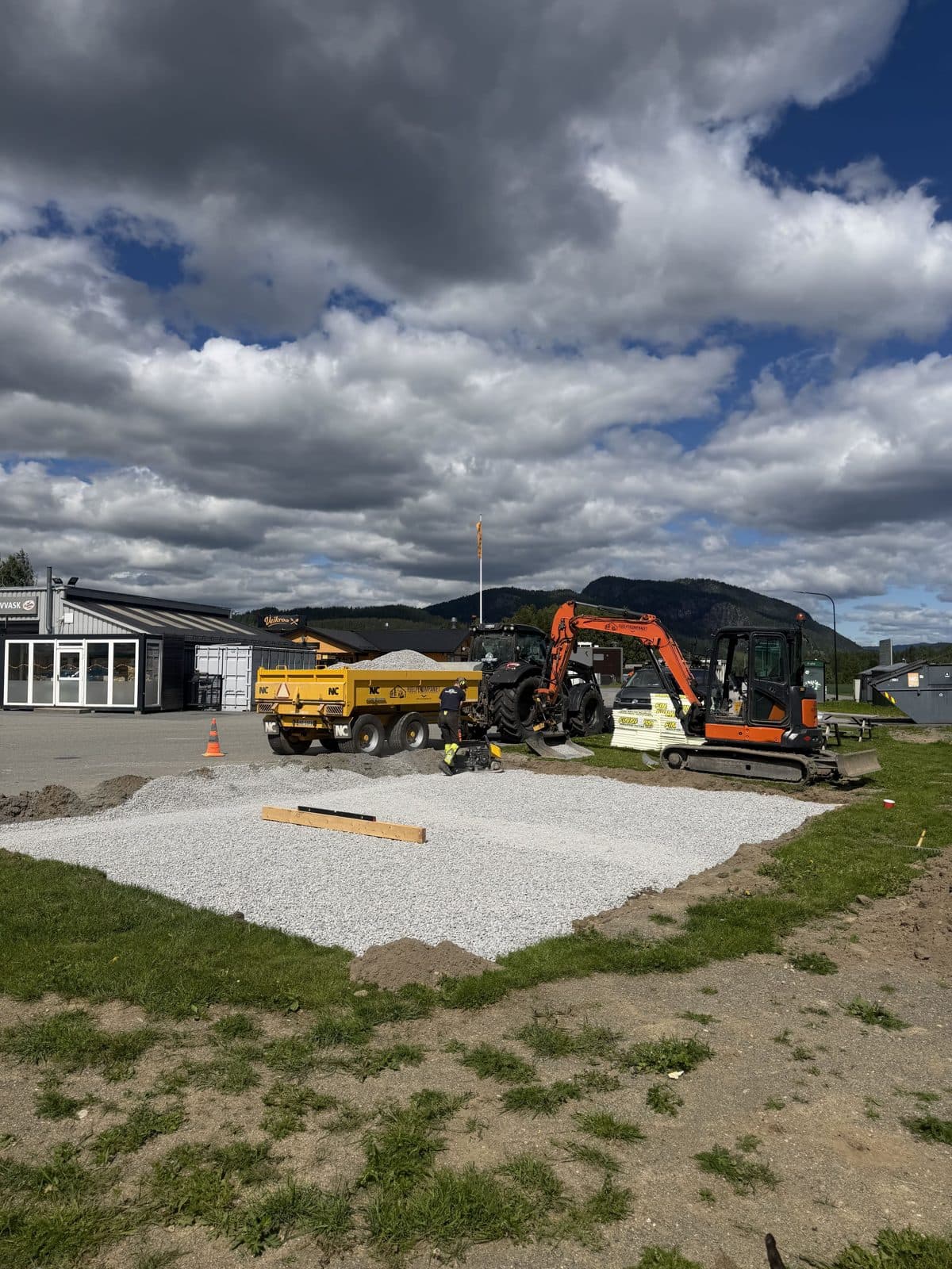 Planert pukkpute med forskaling, med gravemaskin og dumper i bakgrunnen